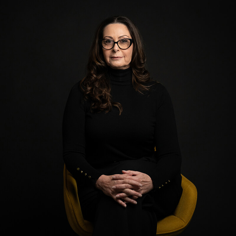 Portrait of Josee Madison, creator of the SMARTER Living™ Blueprint, seated against a dark background