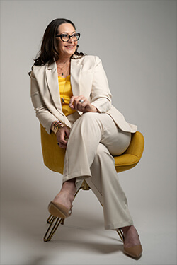 Josee Madison seated in a professional portrait, representing leadership and personal growth